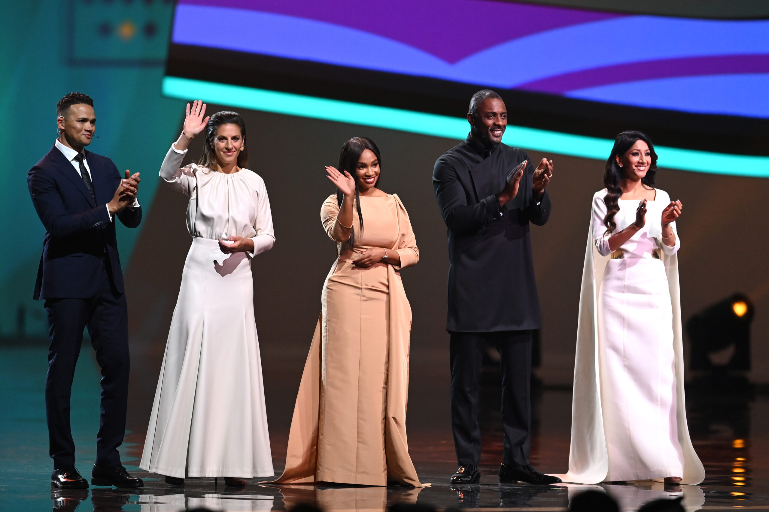 DOHA, QATAR - APRIL 01: Jermain Jenas, Carli Lloyd, Samantha Johnson, Idris Elba and Reshmin Chowdhury are seen on stage during the FIFA World Cup Qatar 2022 Final Draw at the Doha Exhibition Center on April 01, 2022 in Doha, Qatar. (Photo by David Ramos/Getty Images)